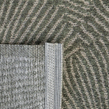 Close-up of a green geometric outdoor rug with a woven geometric shell pattern.