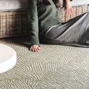 A green geometric patterned outdoor rug with a shell-like design
