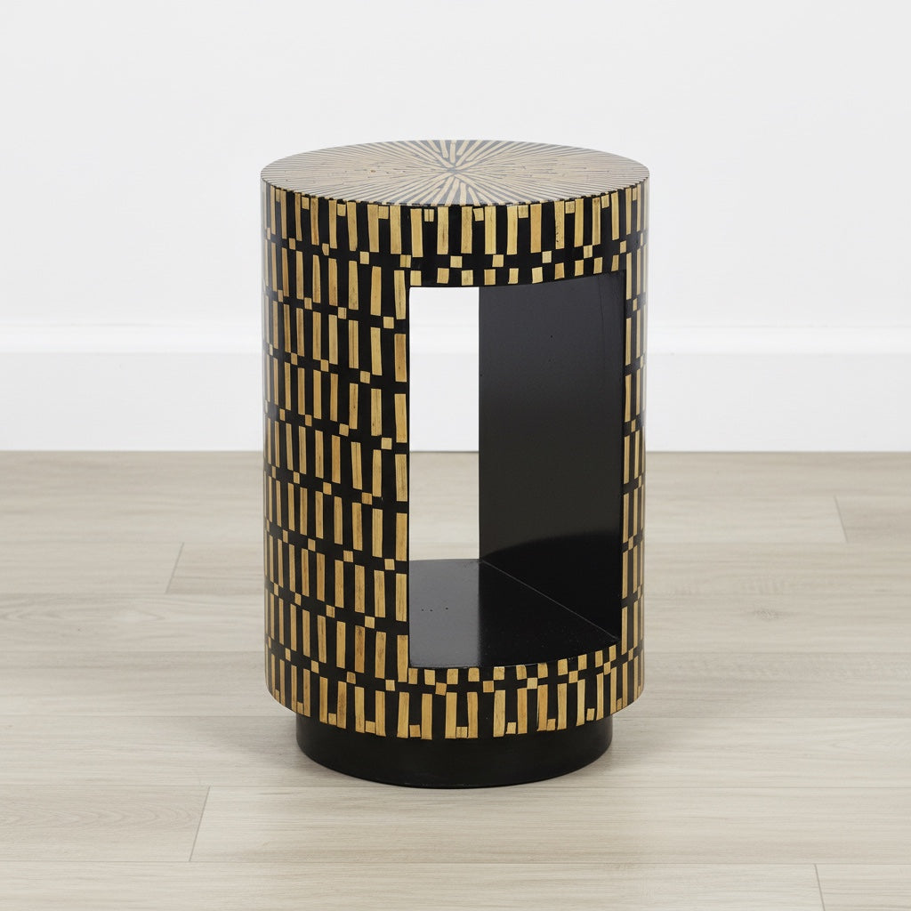 Decorative cylindrical side table with geometric pattern on a wooden floor.