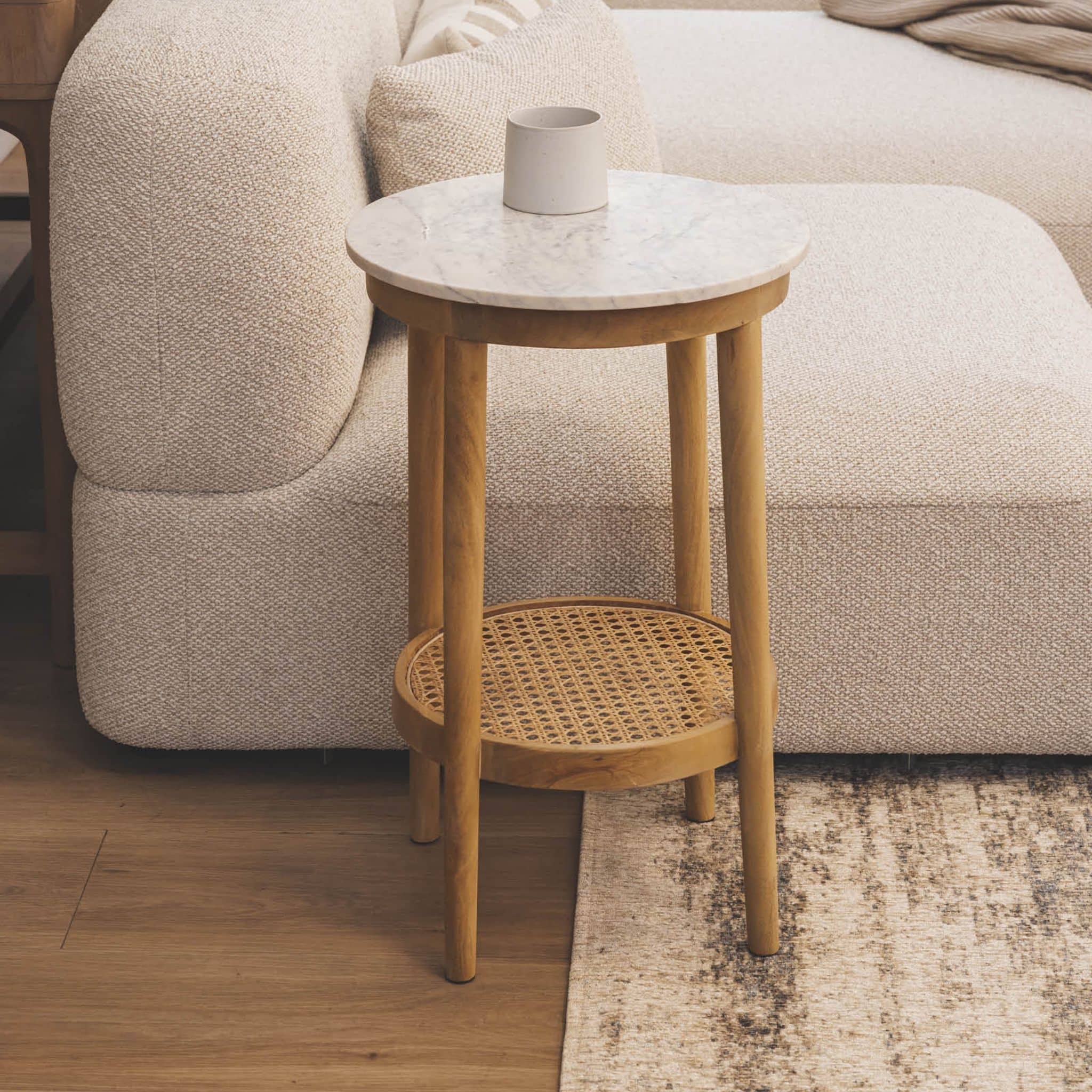 Modern living room side table with white honed marble top and natural cane tier