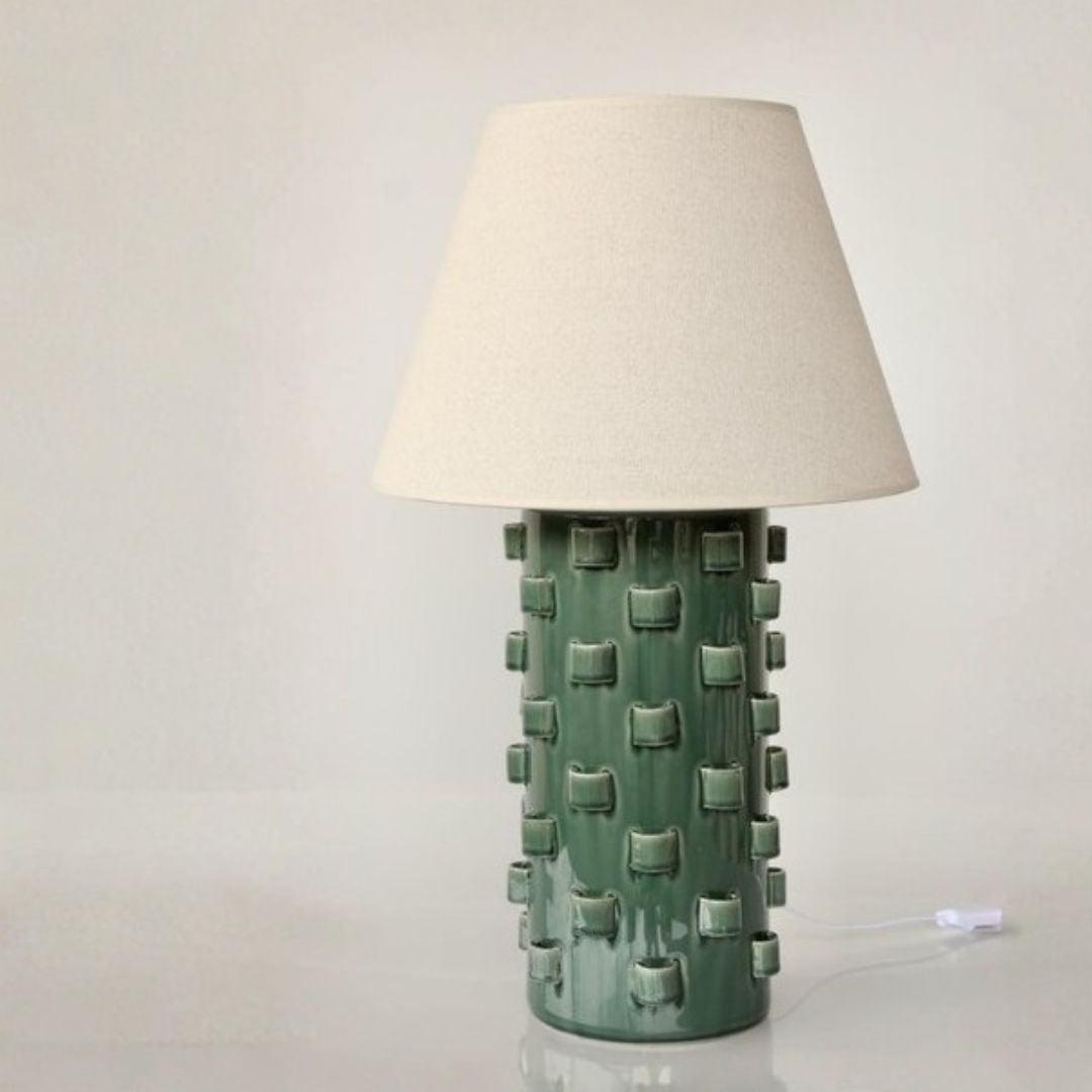 Sculptural ceramic table lamp with a cylindrical base finished in a green glaze.