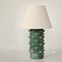 Sculptural ceramic table lamp with a cylindrical base finished in a green glaze.