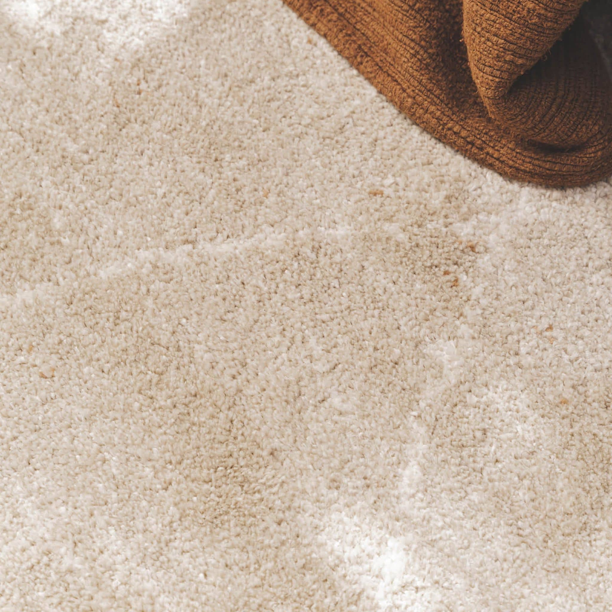 Close-up of a plush Vagabond geometric area rug in the light beige Drift, featuring a soft oatmeal texture with faint, cream-coloured diamond lines