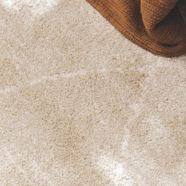 Close-up of a plush Vagabond geometric area rug in the light beige Drift, featuring a soft oatmeal texture with faint, cream-coloured diamond lines