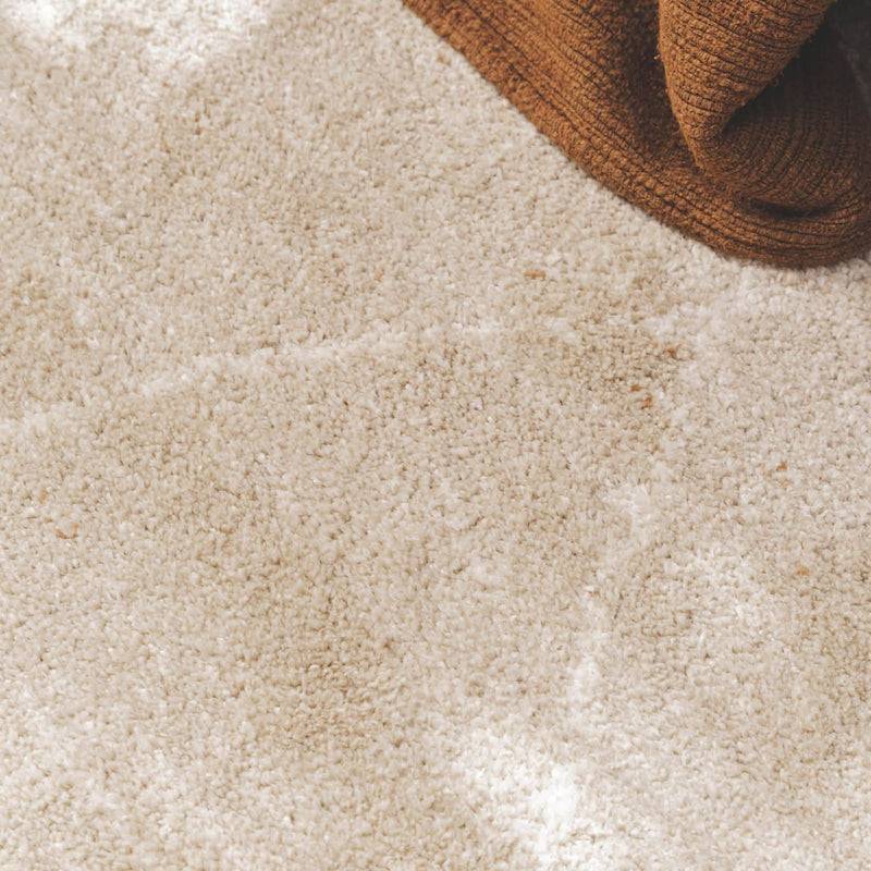 Close-up of a plush Vagabond geometric area rug in the light beige Drift, featuring a soft oatmeal texture with faint, cream-coloured diamond lines