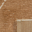 a Vagabond geometric area rug in the camel brown Dryland, showing the plush loop pile texture and backing fold