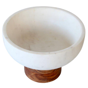 Angled shot of decorative kitchen bowl highlighting smooth marble and grainy wood