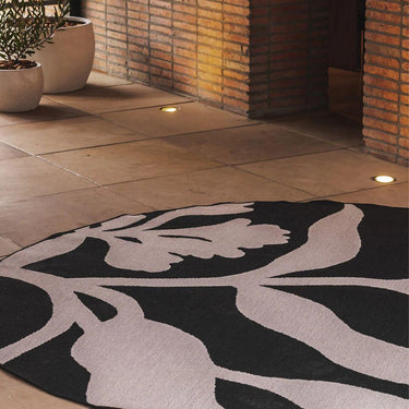 Entryway styled with a dark neutral round outdoor rug for outdoor living