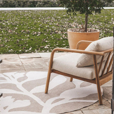 Large 200cm round outdoor rug styled on patio with occasional chair