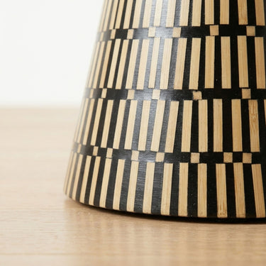 Amelia hourglass bamboo inlay side table base with black and natural striped pattern.