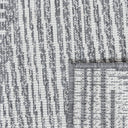 close up of reversible fully outdoor area rug in geometric pattern of triangles and lines in grey and off-white design.