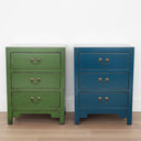 Green and blue Arka elmwood Bedside Tables styled in a minimalist studio with light wood floors and white walls