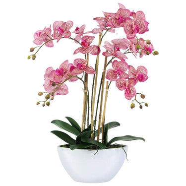 Artificial pink orchid in ceramic vase with green leaves