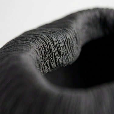 Atoll black ribbed bowl with textured surface and rounded shape.