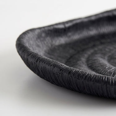 Deep black oval ribbed tray rim with a fine, textured surface and a raised rim.