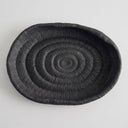 Deep black oval ribbed tray with a fine, textured surface and a raised rim.