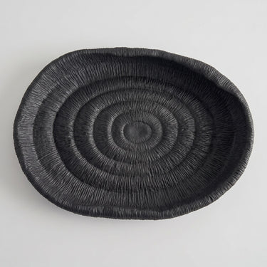 Deep black oval ribbed tray with a fine, textured surface and a raised rim.
