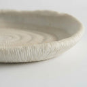 Atoll decorative tray raised rim with an off-white matte finish and ribbed, textured surface.