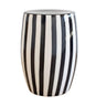 Black striped side table featuring a white ceramic base and bold vertical stripes for modern indoor-outdoor decor