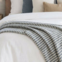 Extra large Celine Lagoon blue and cream accent blanket draped over a bed.