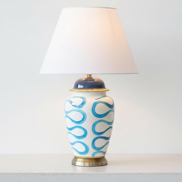 Blue Swirl Lamp with sophisticated brass base detailing styled on a minimalist white console table.