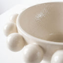 Cream ceramic pedestal bowl with large decorative bobble accents on rim.