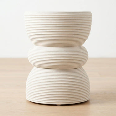 A three-tiered rattan side table with a ribbed, stacked design in white.