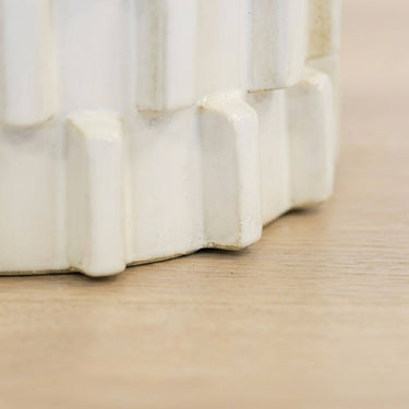 Close up of ceramic stool base showing natural tone variation in glazed block texture