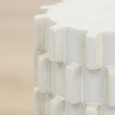 Close up of ceramic stool top edge showing natural tone variation in glazed block detail
