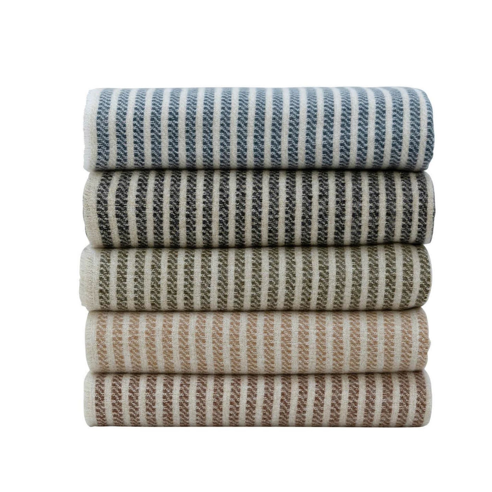 A stack of throws, with stripes in varying earthy tones including blue, gray, green, beige, and brown.