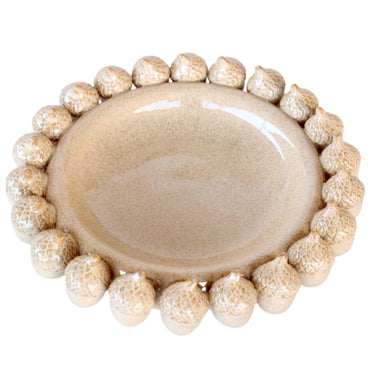 Close-up of the decorative ceramic bowl showing acorn detailing and smooth glaze.