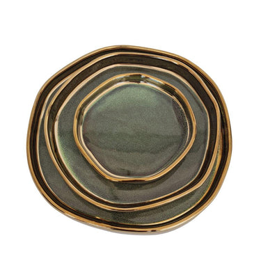 Top view of stacked ceramic tray set with organic shapes and gold rim