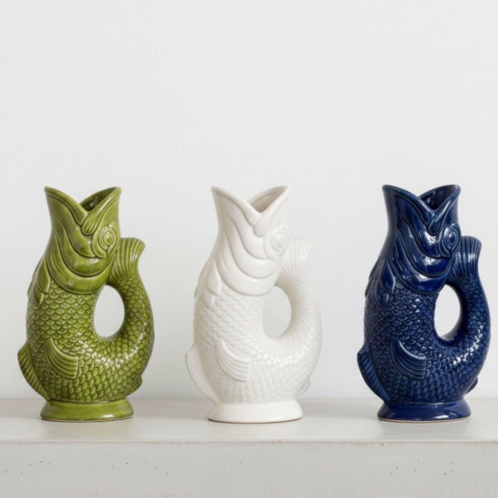 Three sculpted koi fish jug vases lined up in olive green, white, and deep navy ceramic