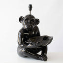 A glossy black ceramic monkey figurine lamp holding a matching bowl, photographed against a plain white background.