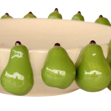 Green ceramic pears on a cream bowl