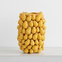 The yellow Ceramic Pineapple Vase styled as a standalone sculptural piece on a minimalist concrete table.