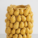 Detailed close-up of the tactile, raised pineapple-inspired texture on the surface of the yellow ceramic vase.