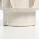 Close-up of a ceramic pot with a glossy off-white glaze pedestal base.