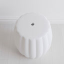 Top view of the ceramic stool showing the central drainage hole and ribbed edge design from above