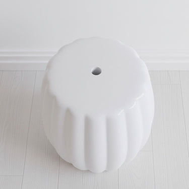 Top view of the ceramic stool showing the central drainage hole and ribbed edge design from above