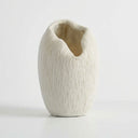 A textured white vase with a unique organic, open top design.