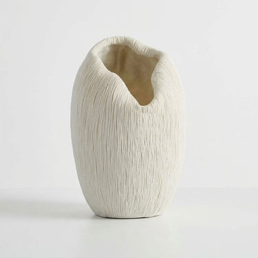 A textured white vase with a unique organic, open top design.