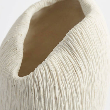  textured rim of the scalloped white vase.