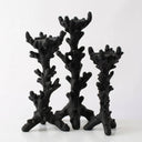 Three black candle holders shaped like branching coral displayed against a plain white background.