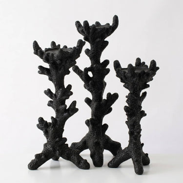 Three black candle holders shaped like branching coral displayed against a plain white background.