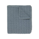 A quilted blanket in a dusty slate blue colour.