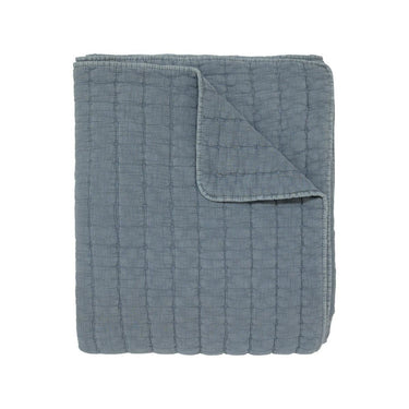A quilted blanket in a dusty slate blue colour.