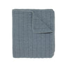A quilted blanket in a dusty slate blue colour.