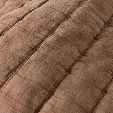 Close-up of a quilted fabric in a warm taupe-brown colour, showing stitched channel quilting.