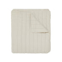 Quilted blanket in a warm off-white or cream colour.